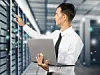 Mitarbeiter steht mit Laptop in einem Serverraum