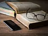 Smartphone, Buch und Brille,