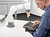Roboterprogrammierer mit Bediensystem vor einem Leichtbauroboterarm