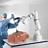 Das Bild zeigt eine Chirurgin beim gemeinsamen Arbeiten mit einem Roboterarm an einem künstlichen Torso