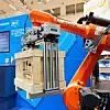 Roboterarm hebt auf der automatica 2022 eine Holzkiste in die Höhe