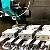 Roboterarm beim Bearbeiten von Metallblöcken