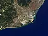 Die spanische Stadt Barcelona ist auf diesem Bild zu sehen, das der japanische Satellit ALOS am 13. September 2010 aufgenommen hat. In der rechten oberen Ecke ist der kreisförmige Plaça de les Glòries Catalanes zu sehen, der im ursprünglichen Stadtplan als Stadtzentrum vorgesehen war. Entlang der Küste ist der Hafen von Barcelona zu erkennen, der zu den zehn größten Containerhäfen Europas gehört.