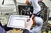 Mensch mit Tablet vor Roboterarm,