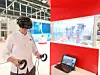 Mann mit Virtual Reality Brille vor einem Display mit virtuellen Robotern