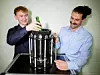 Eine kleine Flasche hat Platz im ersten Mini-Kühlschrank mit künstlichen Muskeln. Student Nicolas Scherer (l.) und Doktorand Lukas Ehl forschen im Team der Professoren Stefan Seelecke und Paul Motzki am neuen Kühlsystem.