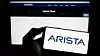 Stuttgart, Germany - 04-28-2023: Person holding cellphone with logo of computer networking company Arista Networks Inc. on screen in front of webpage. Focus on phone display.
