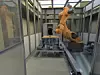 Roboter bearbeitet Holz in Roboterzelle