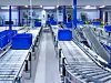 In der neuen Logistikhalle werden Transportkisten auf mehreren Förderstrecken kommissioniert.