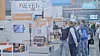 Menschen am Keyence-Messestand mit Sensor- und Automatisierungsprodukten  auf der Motek in Stuttgart.