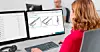 Frau arbeitet am Schreibtisch mit zwei Monitoren und technischer Produktsoftware