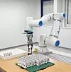 Der kollaborative Roboter bestückt eine Leiterplatte mit großformatigen Kondensatoren. Die modulare Automatisierung entlastet Mitarbeitende, stabilisiert den Prozess und erhöht den Durchsatz auch bei kleinen Losgrößen und hoher Variantenvielfalt.