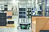 Die Fahrerlosen Transportsysteme bewegen sich frei durch die Werkshalle und transportieren mit Materialkästen befüllte Gestellaufbauten von der Fertigungsversorgung zu den Arbeitsstationen