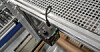 Die AM-T100 3D-Kamera von Schmersal mit Kabeln an einer Metallstruktur in einer Industrieumgebung.