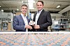 Die cellumation-Gründer Dr.-Ing. Hendrik Thamer (rechts) und Dr.-Ing. Claudio Uriarte mit einem Element der patentierten Celluveyor-Technologie. Nach der Übernahme durch Symbotic soll die softwaregesteuerte Sortiertechnik künftig auch in dessen Robotiksystemen zum Einsatz kommen.